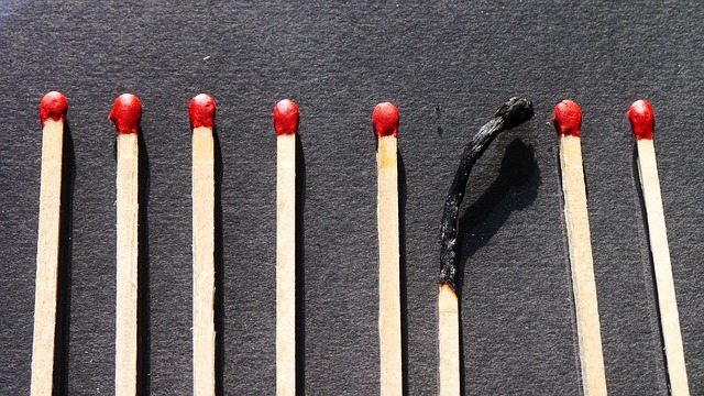 One burned match among other unlit matches